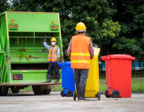 Garbage collection service,Rubbish cleaner man in a uniform work Garbage collection service,Rubbish cleaner man in a uniform working together on emptying dustbins for trash removal with truck loading waste and trash bin,Recycling concept.